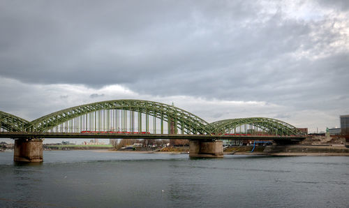 Arch bridge over river against sky