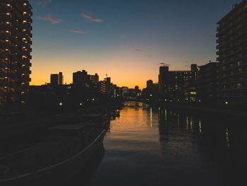 Illuminated buildings against sky at sunset