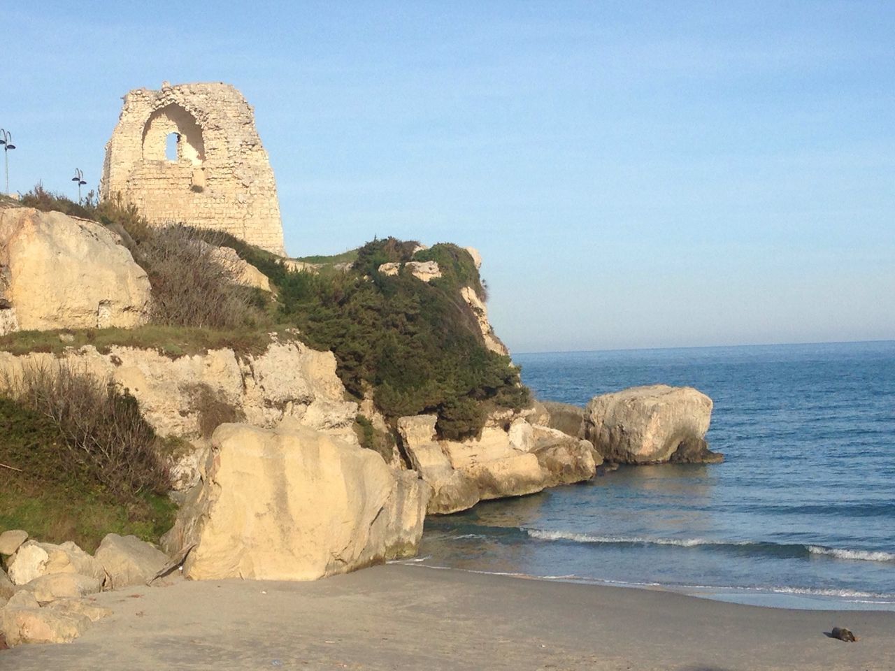 sea, water, horizon over water, clear sky, built structure, rock formation, beach, tranquility, rock - object, tranquil scene, cliff, architecture, scenics, beauty in nature, nature, shore, sky, building exterior, copy space, rock