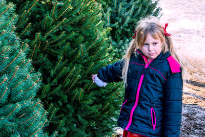 Adorable little girl points at the tree she wants to take home for christmas