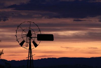 Silhouette windmill against sky during sunset