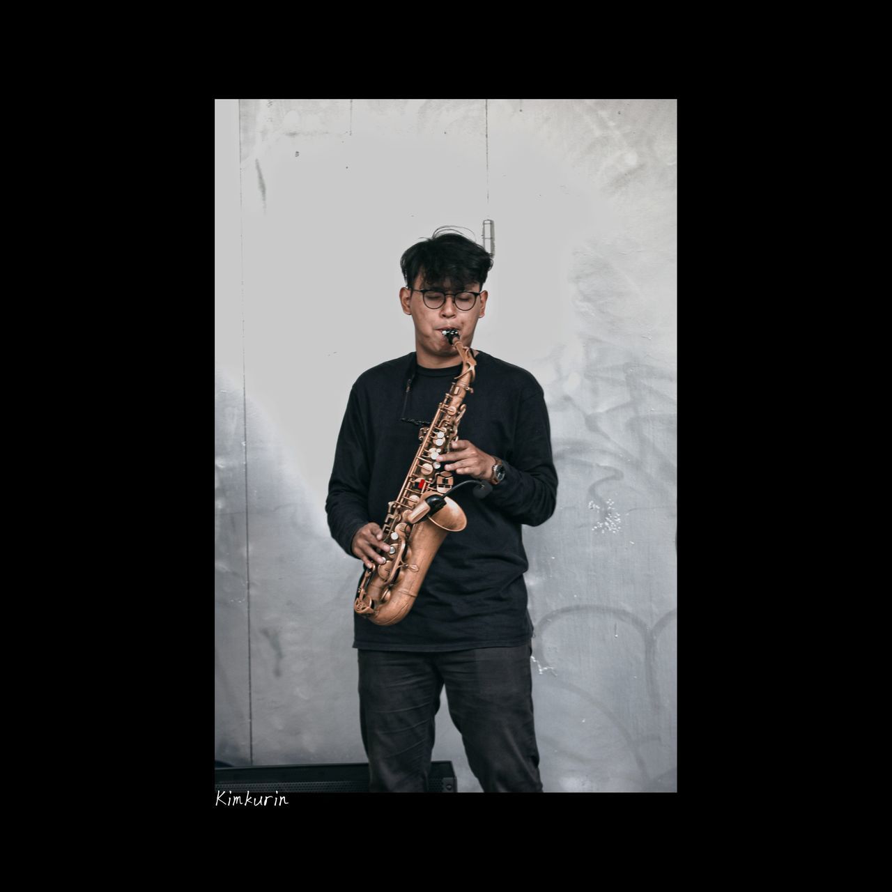 musical instrument, music, one person, musician, saxophone, woodwind instrument, arts culture and entertainment, performance, skill, men, adult, front view, indoors, holding, standing, wind instrument, copy space, musical equipment, guitar, saxophonist, person, young adult, black background, studio shot