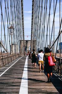 Rear view of people walking on brooklyn bridge