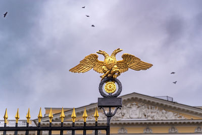 Low angle view of birds on building against sky