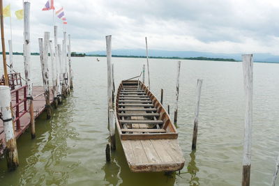 Wooden posts on pier over sea against sky