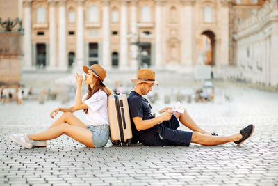 Tired tourists looking at a map and drinking coffee take away. vacation in italy. relocation