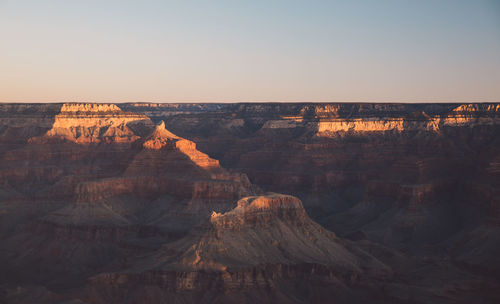 Scenic view of dramatic landscape against clear sky during sunset