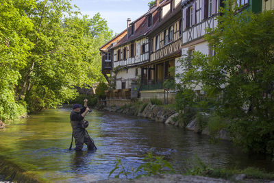 People standing by river against building