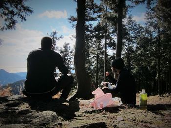 Rear view of people sitting in forest