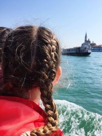 Rear view of woman with braided hair by grand canal against sky