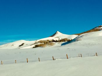 Scenic view of snowcapped mountains against clear blue sky