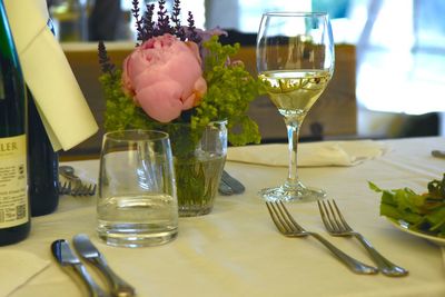 Close-up of white wine by vase on table in restaurant