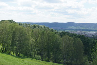 Scenic view of green landscape and mountains against sky