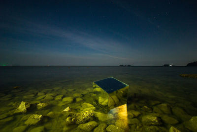 Scenic view of sea against clear sky at night