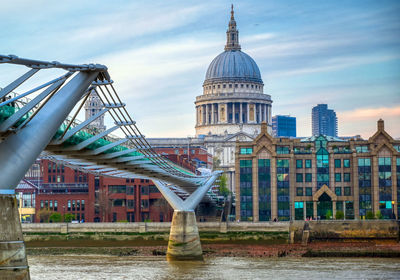 Bridge over river against buildings in city