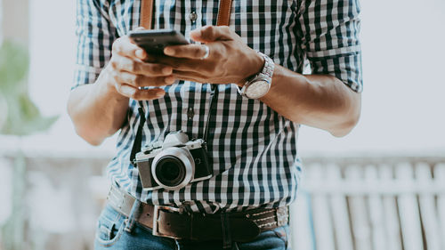 Midsection of man using mobile phone