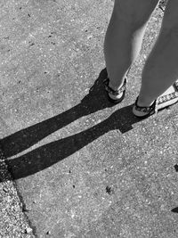 Low section of woman standing on road