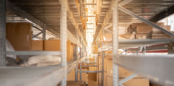 The storage warehouse of the cardboard boxes put on the stainless steel shelves.