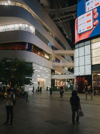 People walking on illuminated street in city