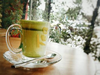 Cup of green tea latte on table