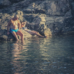 Full length of woman on rock in sea