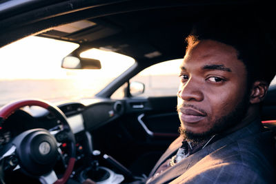 Portrait of young man sitting in car