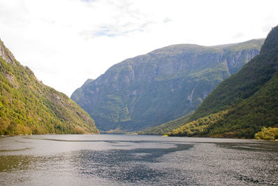 Scenic view of lake by mountains against sky