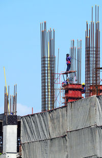 Man working at construction site against clear sky