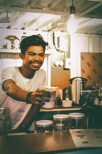 Portrait of smiling young man sitting at table