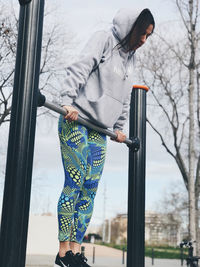 Full length of woman exercising on monkey bars