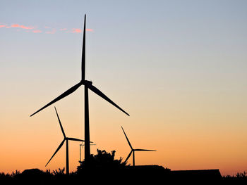 Low angle view of silhouette windmill against sky during sunset