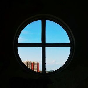 Close-up of cityscape against sky seen through window