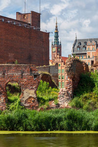 View of old building by river against sky