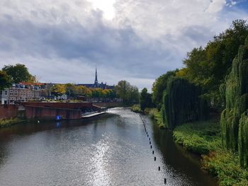 River amidst buildings in city against sky