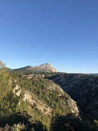 Scenic view of rocky mountains against clear blue sky