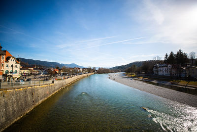 River amidst buildings in city against sky