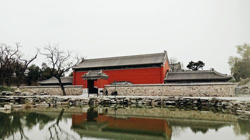 Built structure by lake against clear sky