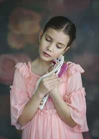 Girl with eyes closed embracing doll