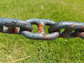 Close-up of rusty chain on field