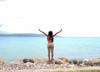 Rear view of woman standing on beach