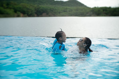 Mother and cute son enjoying in swimming pool