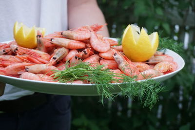 Midsection of man holding seafood in plate