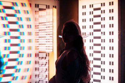 Side view of young woman seen through glass