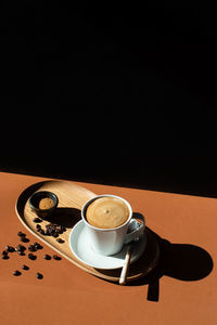 Coffee cup on table against black background