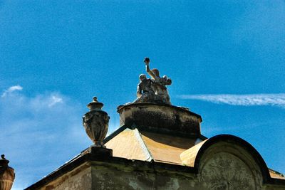 Low angle view of statue against building against sky