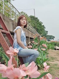 Side view of young woman sitting outdoors