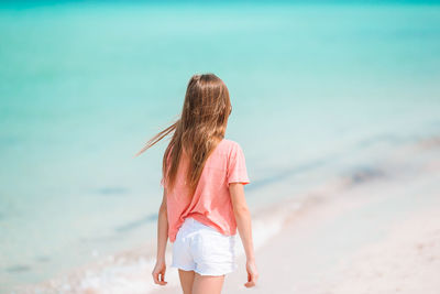 Rear view of girl standing on beach