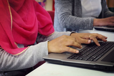 Midsection of woman working on laptop at home