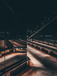 Empty footpath in illuminated city at night