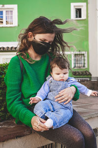 Portrait of mother and daughter sitting outdoors